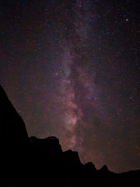 Milky Way galaxy visible over Moraine Lake, with silhouetted mountain peaks under a starry sky in Banff National Park.
