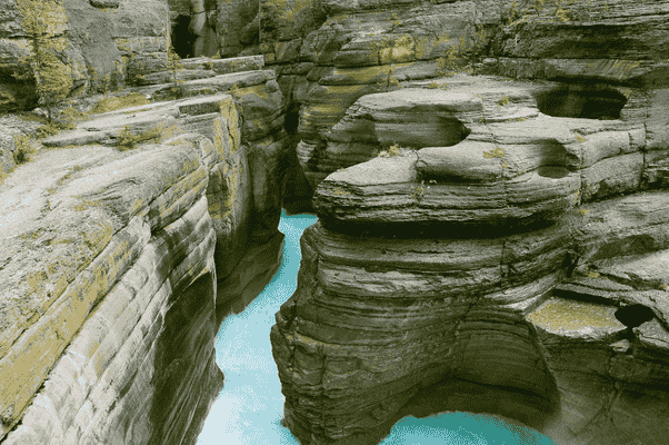 Narrow limestone gorge carved by turquoise glacial water at Mistaya Canyon in Banff National Park, Alberta