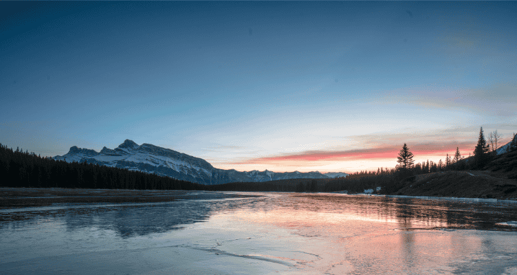Sunset over frozen Two Jack Lake with mountain reflections in Banff National Park, Canadian Rockies
