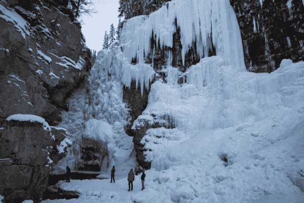 Visitors exploring the frozen waterfalls and icy trails of Johnston Canyon in Banff National Park during winter.