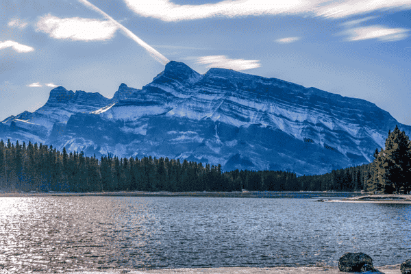 Mount Rundle rising above Two Jack Lake in Banff National Park with calm water and forested shoreline.